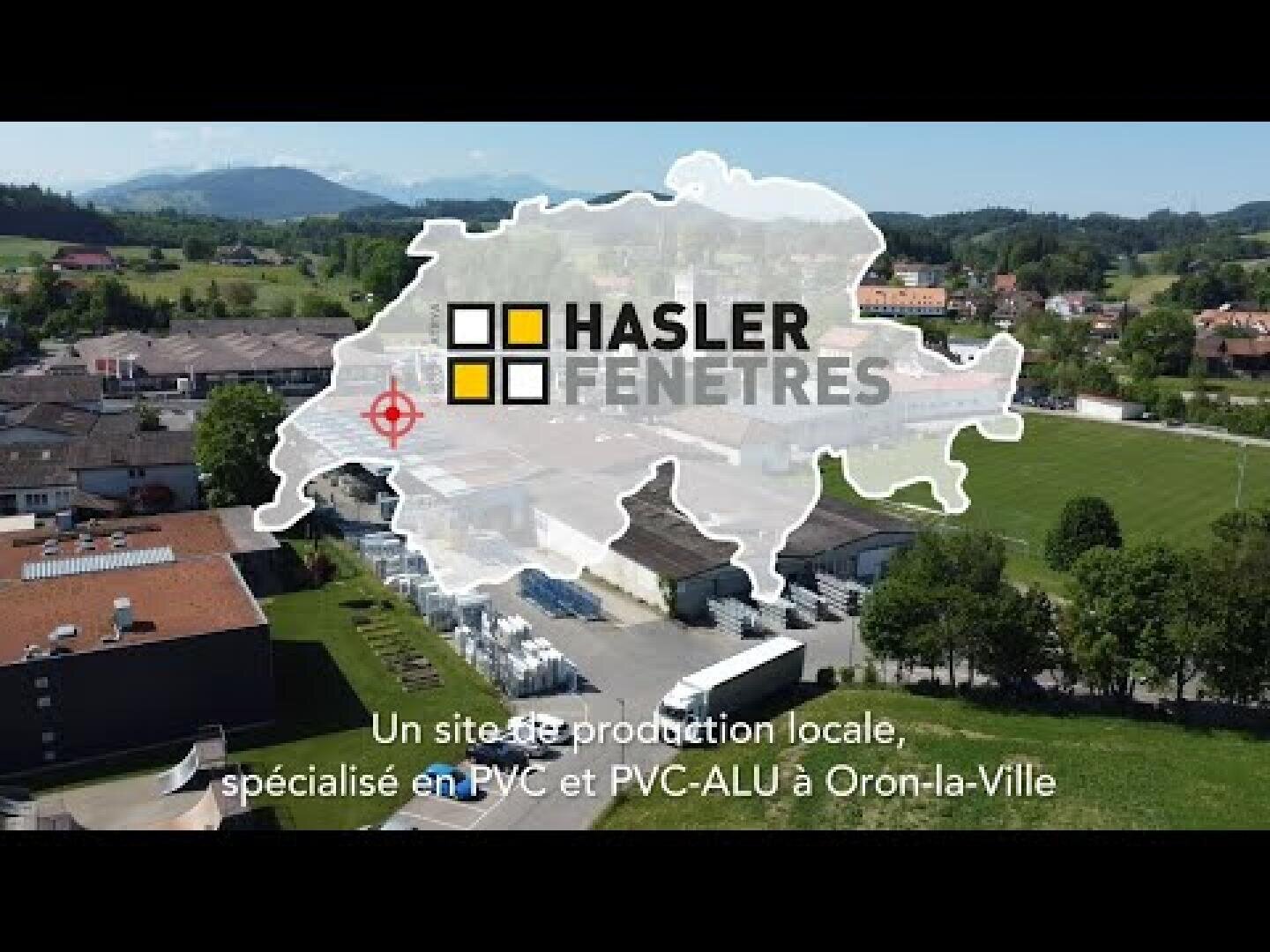 Vue aérienne d'une usine avec une carte blanche de la Suisse, le logo de Hasler Fenêtres et un texte en français sur un site local de production de fenêtres en PVC et PVC-ALU à Oron-la-Ville.
