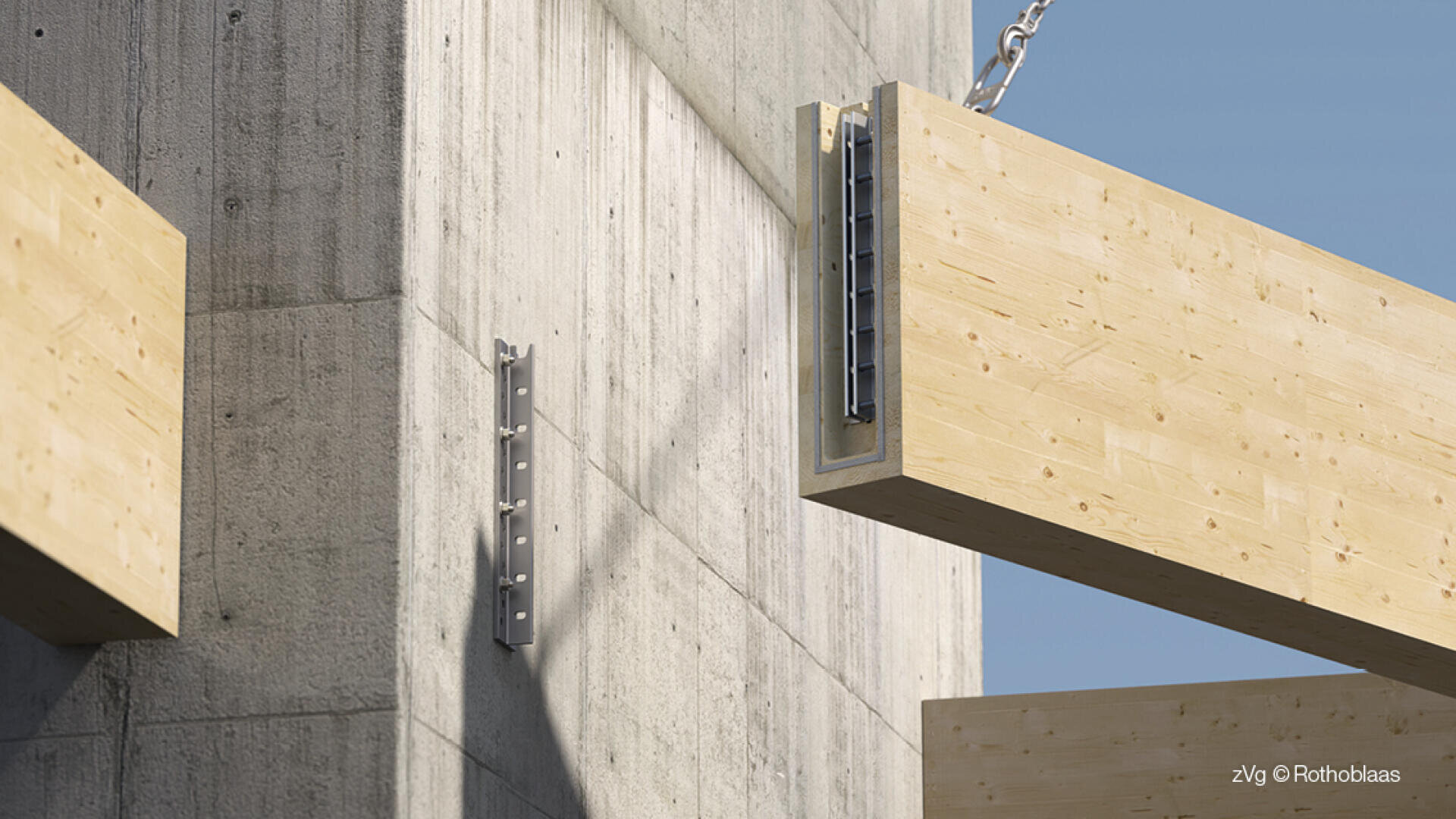 Ein großer Holzbalken wird an einer Kette in Richtung einer Betonwand mit einer Metallhalterung gehoben und ist bereit für die Montage. Ein weiterer Holzbalken ist im Hintergrund zu sehen. Der Himmel ist klar und blau.