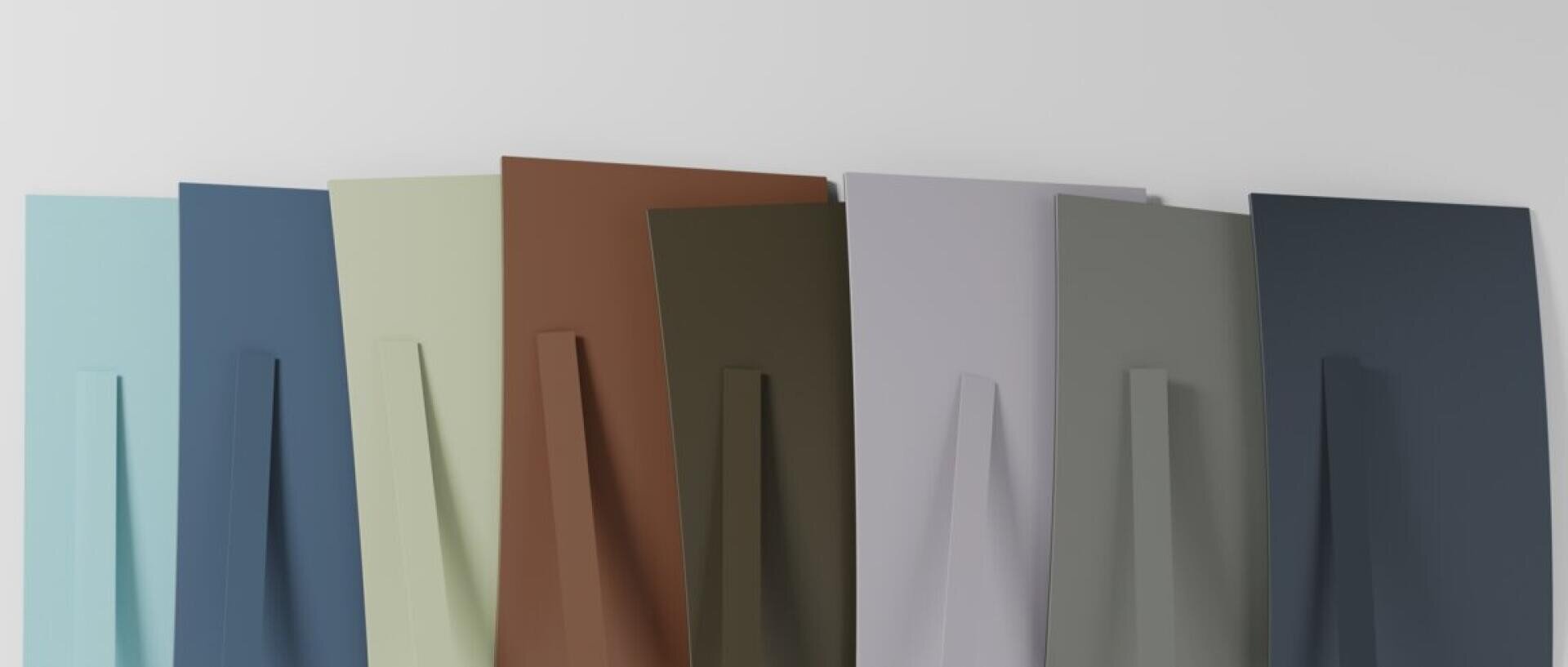 Une série de huit panneaux rectangulaires colorés, chacun avec un support vertical à l'arrière, est adossée à un mur blanc. Les panneaux sont dans des tons de bleu, de vert, de brun, de gris et de beige.