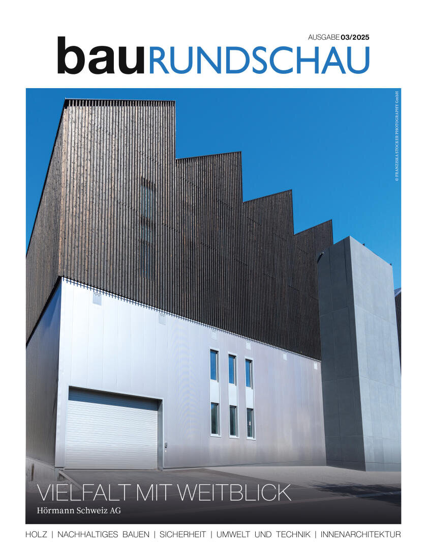 Modernes Industriegebäude mit Metallfassade und hohen, vertikalen Holzlatten vor strahlend blauem Himmel auf dem Titelbild der bauRUNDSCHAU (03/2025). Der Text hebt Architektur und Nachhaltigkeit hervor.