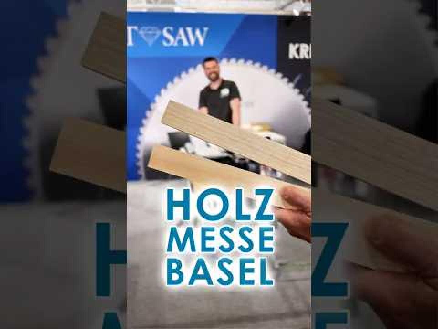 Eine Person steht vor einem Messestand an einer Veranstaltung mit zwei im Vordergrund gehaltenen Holzbrettern. Der Text HOLZ MESSE BASEL ist über das Bild gelegt.