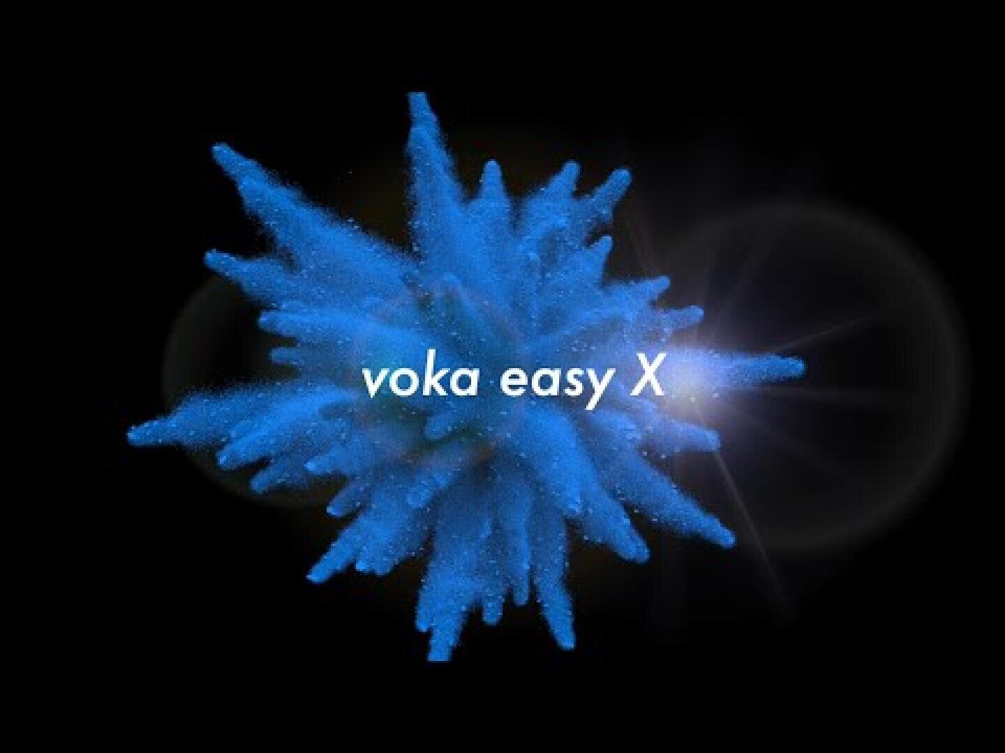 Leuchtend blaue Pulverexplosion auf schwarzem Hintergrund mit leichtem Streulicht und dem Text voka easy X in weißer Farbe in der Mitte des Bildes.