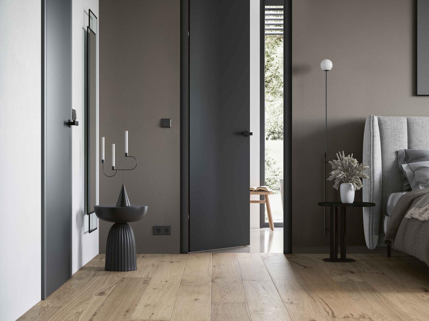 Chambre minimaliste avec parquet clair, lit gris, table d'appoint noire avec vase, grand miroir, chandelier noir moderne et une porte noire ouverte menant à une pièce lumineuse d'où l'on peut voir une chaise.
